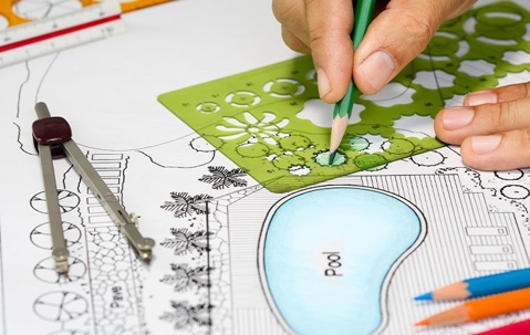 person designing a landscape on paper